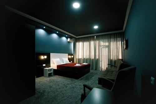 Habitación de hotel con cama, sofá y silla en Hotel Rero, en Kutaisi