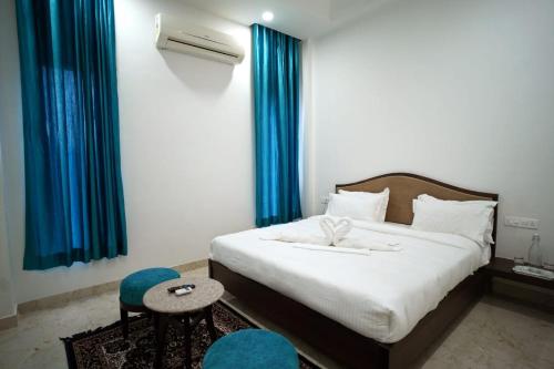 a bedroom with a bed with blue curtains and a table at 1st Luxury in Rāmdevra