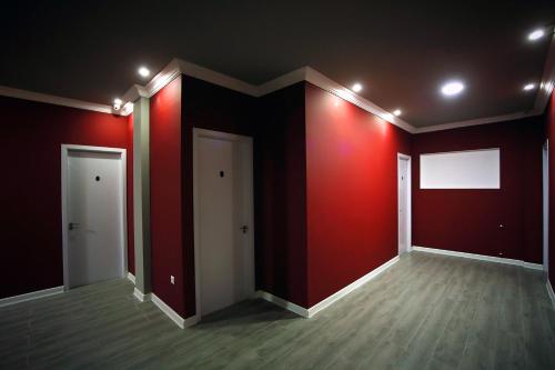 an empty room with red walls and a white door at Hotel Rero in Kutaisi