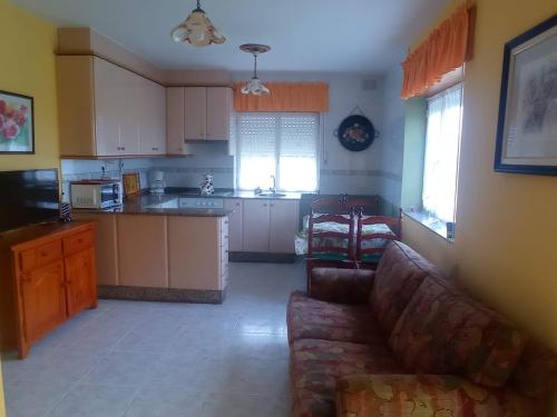 a living room with a couch and a kitchen at Apartamento Playa de Coto in Barreiros