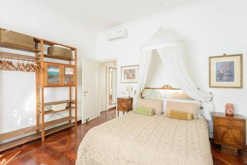 ローマにあるAppartamento Fioreのベッドルーム(天蓋付き白いベッド1台付)
