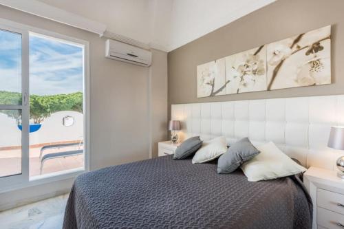 sypialnia z łóżkiem i dużym oknem w obiekcie SEA VIEW Holiday Home in Marbella Resort w Marbelli