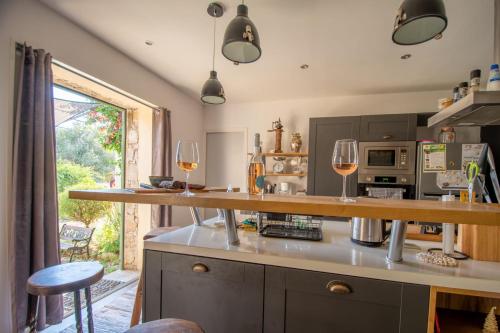 - une cuisine avec deux verres de vin sur un comptoir dans l'établissement Villa Anna location de vacances au Calme en Corse à proximité de Calvi, à Zilia