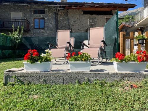 three chairs on a patio with flowers in them at Ca di Nadia in Aosta