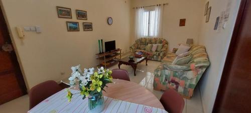 a living room with a table with a vase of flowers on it at Apt. Idilfa in Praia
