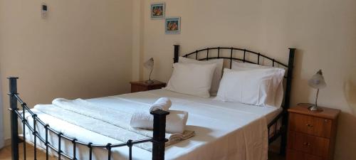 a bed with a black frame and white sheets and pillows at Apt. Idilfa in Praia