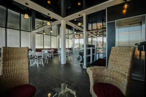 a restaurant with chairs and tables and windows at Hotel Rero in Kutaisi