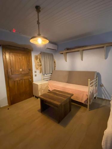 Un dormitorio con una cama y una mesa. en Περιβόλι του Οδυσσέα, en Volissos