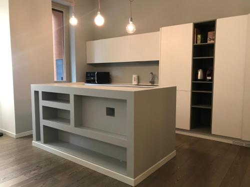 a kitchen with a island in the middle of a room at CaseOspitali - Casa Raffaella, moderno bilocale vicino al San Raffaele in Segrate