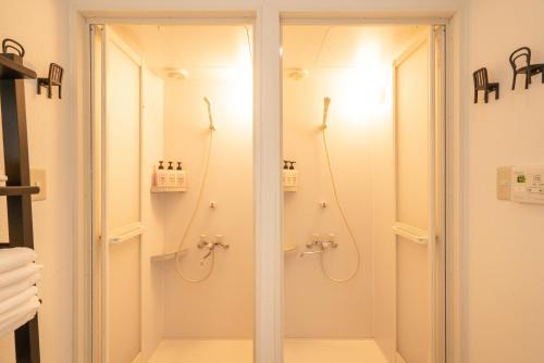 La salle de bains est pourvue d'une douche avec une porte en verre. dans l'établissement Otuska house with 2BR near the Yamanote line, à Tokyo