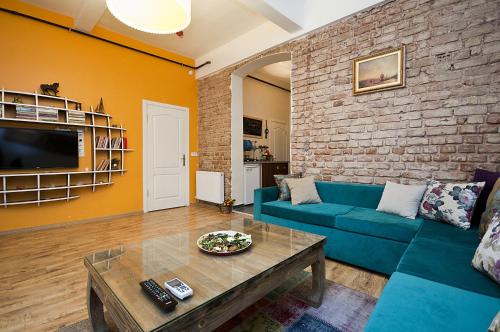 a living room with a blue couch and a brick wall at Cumbalı 27 in Istanbul