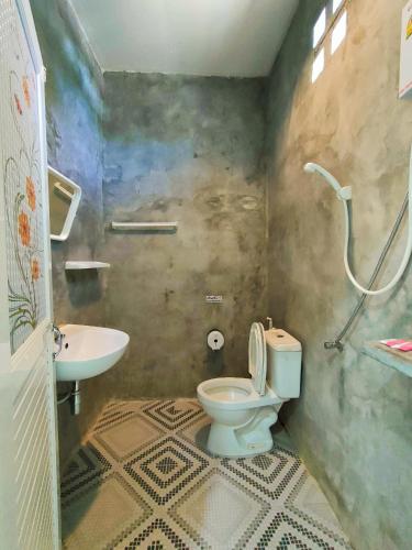 a bathroom with a toilet and a sink at บ้านไม้หอมบูติค สวนผึ้ง in Ban Bo Wi