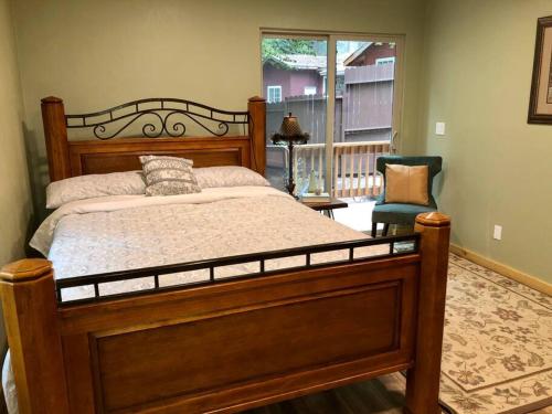a bedroom with a wooden bed and a chair at Modern Cabin Get Away - close to APPLE HILL in Pollock Pines