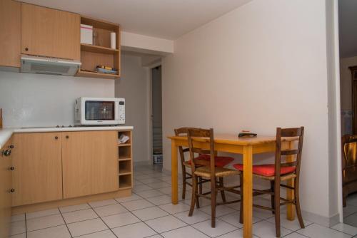 Una cocina con mesa y sillas y un microondas. en Entre Lac et Montagne, en Veyrier-du-Lac