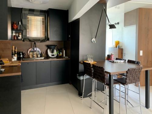 uma cozinha com armários pretos e uma mesa e cadeiras em L’ Appart du Golf em Saint-Cyprien