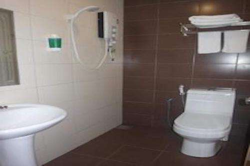 a bathroom with a toilet and a sink at Super OYO 90579 U Inn in Miri