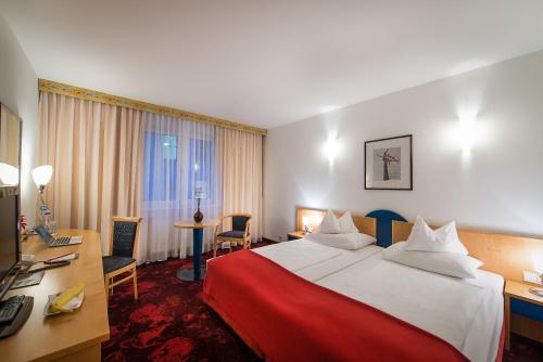 a hotel room with a large bed and a desk at Hotel Boltzmann in Vienna