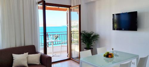 a living room with a table and a view of the ocean at Simon Sea View in Sitia