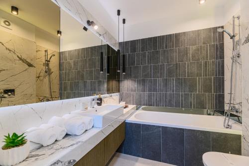 uma casa de banho com 2 lavatórios e uma banheira. em Luxury Landing Apartments Complex Qualis Brasov em Brasov