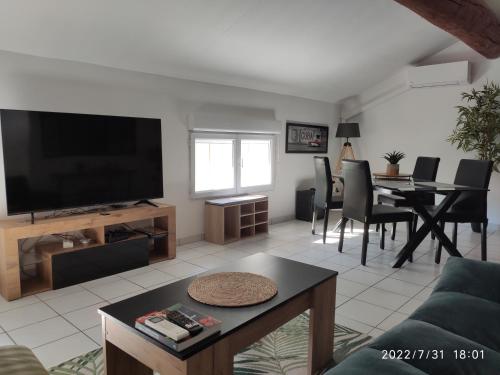 un salon avec une télévision et une salle à manger dans l'établissement Le mas, à Arles