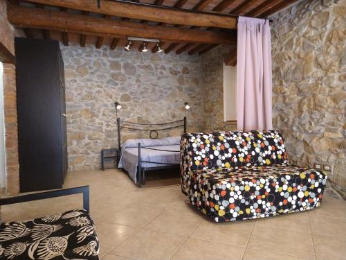 salon z krzesłem i łóżkiem w obiekcie Casa Vanessa w mieście Suvereto