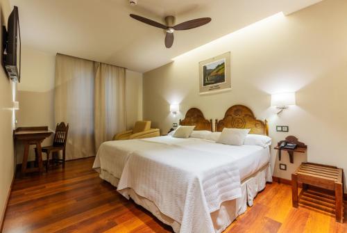 a bedroom with a large bed and a ceiling fan at Don Paco in Llanes