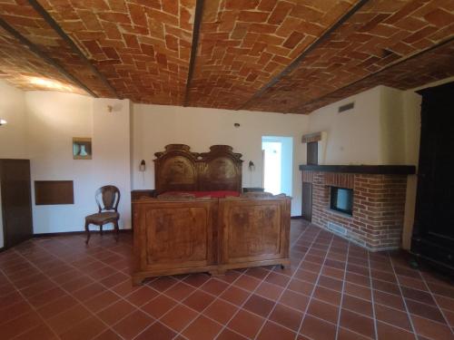 a large room with a bed and a fireplace at Cascina Flino - Tra le vigne - Appartamento 2 in Alba