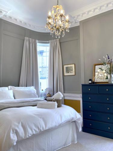 a bedroom with a large bed and a chandelier at Exclusive Georgian apartment in centre of Bath in Bath