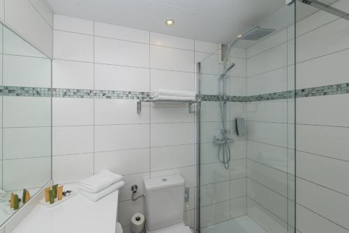 a white bathroom with a shower and a toilet at Hotel Boltzmann in Vienna
