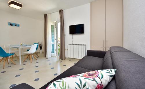 a living room with a couch and a table at in olive garden in Starigrad-Paklenica