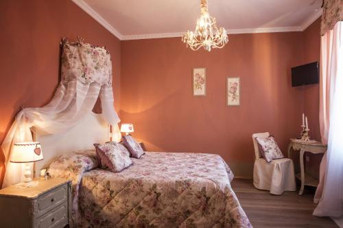 1 dormitorio con cama y lámpara de araña en B&B Il Biancospino en Abbadia San Salvatore