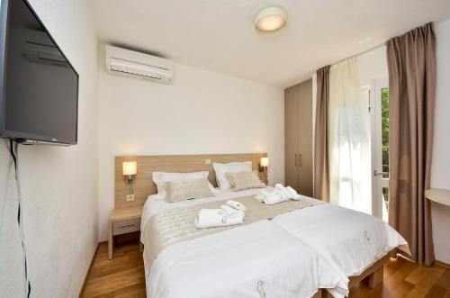 a bedroom with a white bed with towels on it at in olive garden in Starigrad-Paklenica