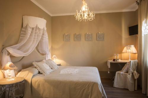 a bedroom with a white bed and a chandelier at B&B Il Biancospino in Abbadia San Salvatore