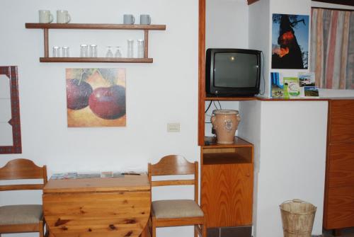 a room with a desk and a tv and a table and chairs at Apartamentos Finca Wapa in Frontera