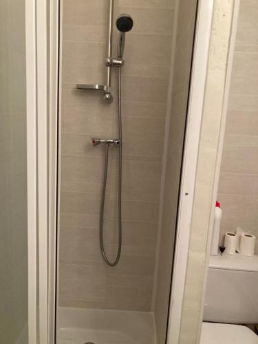 een douche met een douchekop in de badkamer bij Studio cosy 5 personnes aux pieds des pistes. in Le Dévoluy