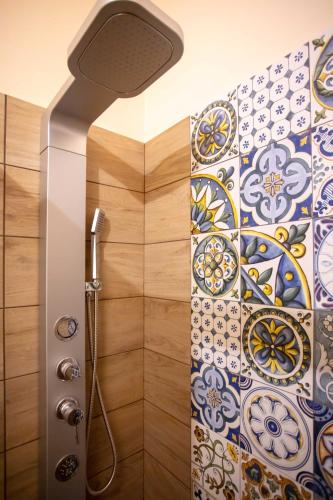 a shower with a shower head and a tile wall at Il Paesaggio Lunare in Aliano