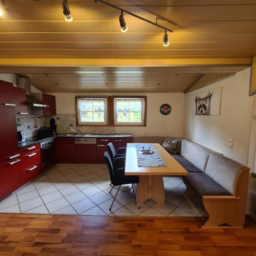 a kitchen and a living room with a table and a couch at Ferienwohnungen Claudia in Altossiach