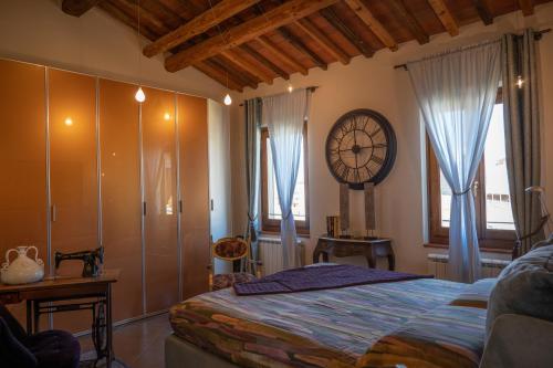 a bedroom with a bed and a clock on the wall at Cathedral-luxury-stay sauna & massage in Pescia