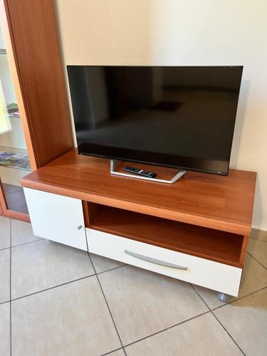 TV de pantalla plana en un soporte de madera en Marzan 12 en Peschiera del Garda