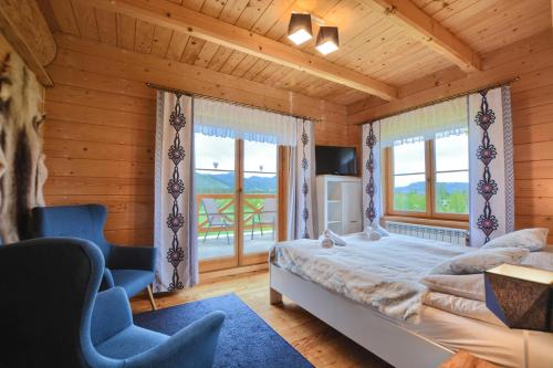 a bedroom with a bed and a large window at Willa ANTONÓWKA in Kościelisko