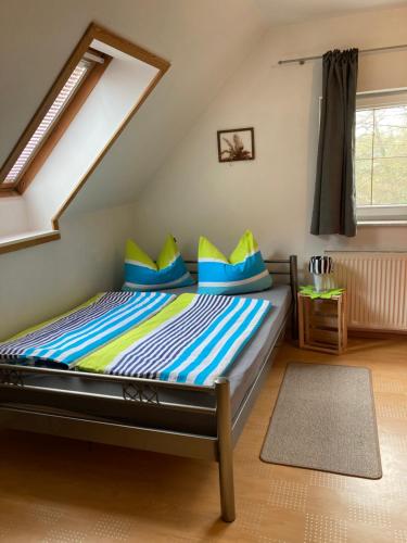 1 dormitorio con 1 cama con almohadas azules y amarillas en Ferien in Sachsen, en Bischofswerda