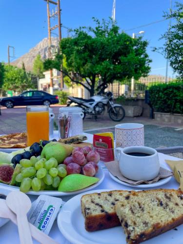 a table with a plate of food with grapes and bread at Vasilios Marinos Rooms in Korinthos