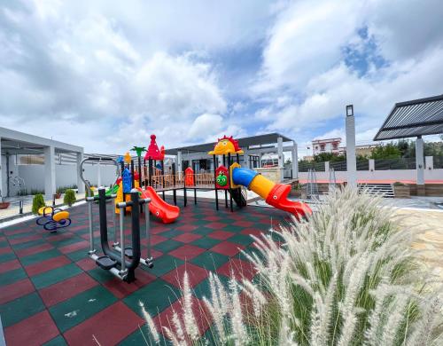 a playground with a slide and a play structure at Olivia Chalet فلة أوليفيا in Al ‘Aqar