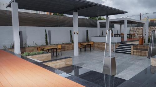 a patio with tables and chairs and a building at Olivia Chalet فلة أوليفيا in Al ‘Aqar