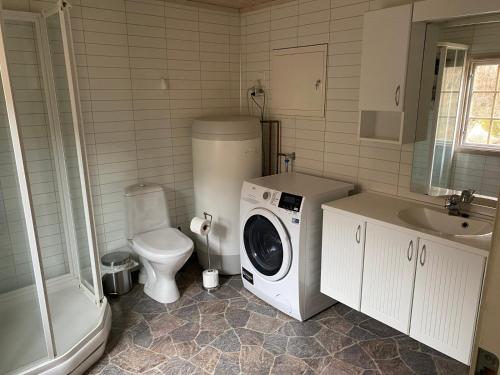 a bathroom with a washing machine and a toilet at Nissedal- en liten perle ved Nisser in Nordbygdi