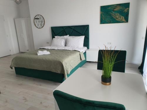 1 dormitorio con 1 cama, 1 mesa y 1 silla en Grey Residence Apartments en Tunari