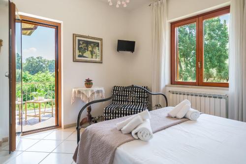 アグローポリにあるB&B Villa Le Mattineのベッドルーム1室(ベッド1台、椅子、窓付)