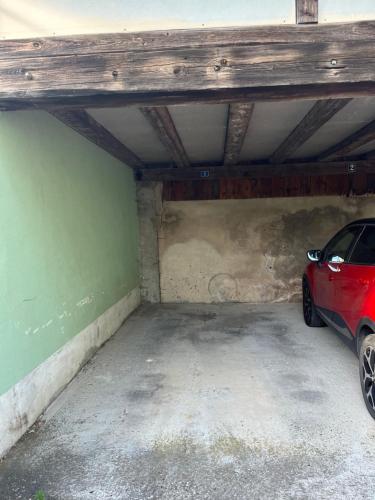 a garage with a red car parked in it at L'appart du RIED in Heidolsheim