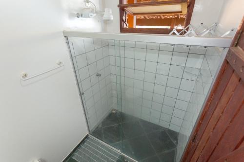 a bathroom with a glass shower with a mirror at Pousada Céu de Estrelas in Bonito