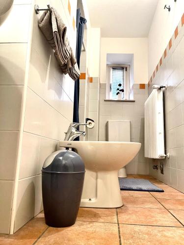 a bathroom with a white toilet and a sink at Cá d la trifola free parking in Alba